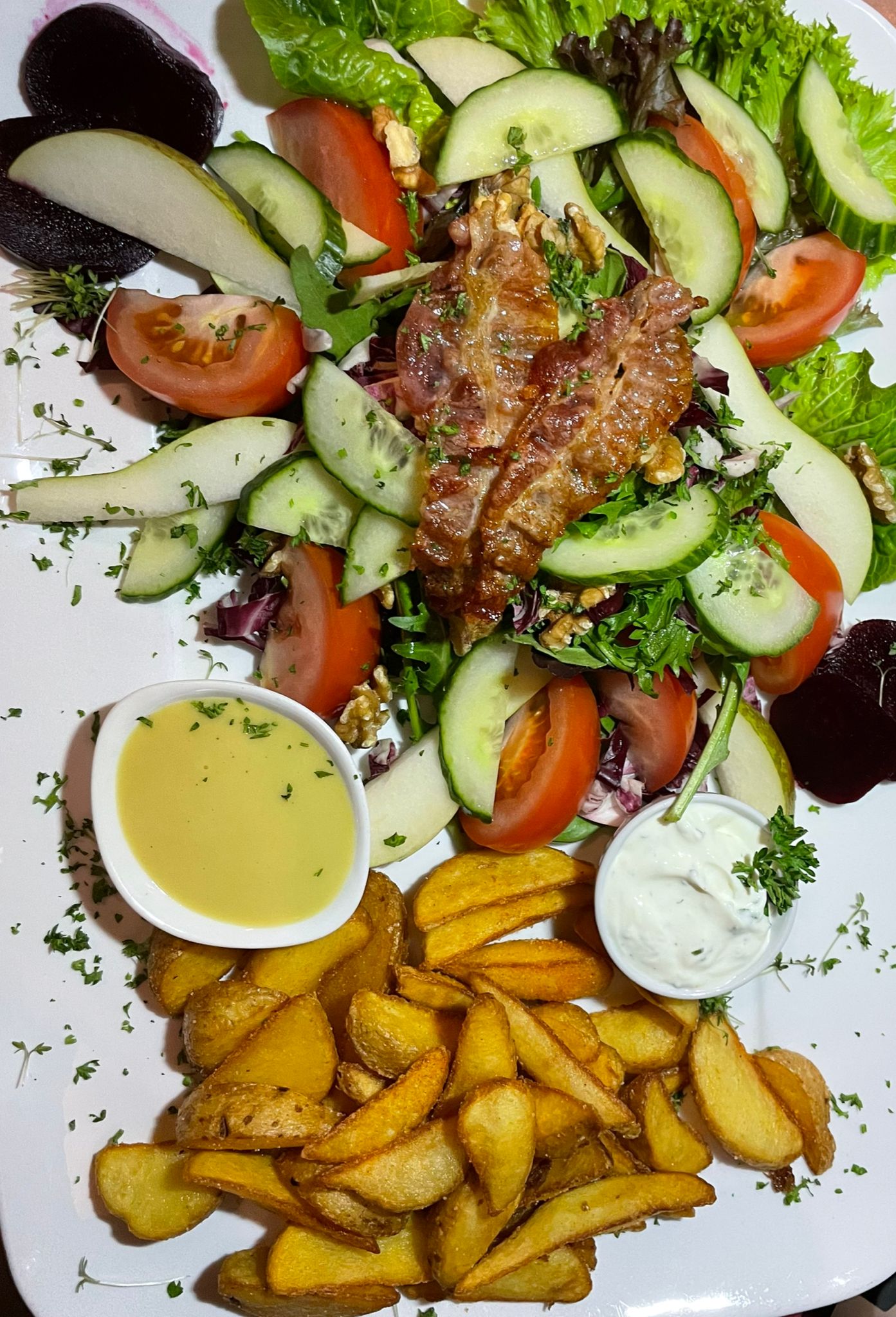 Bunter Salatteller mit knusprigem Speck und Kartoffelspalten